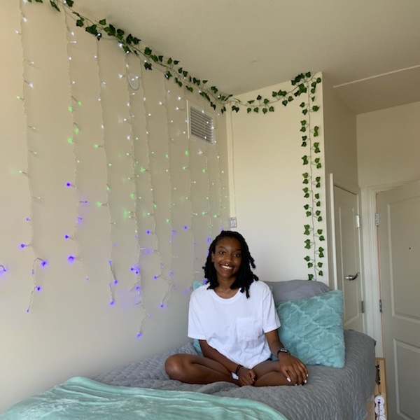 Our youngest daughter poses on her bed in her decorated dorm room.