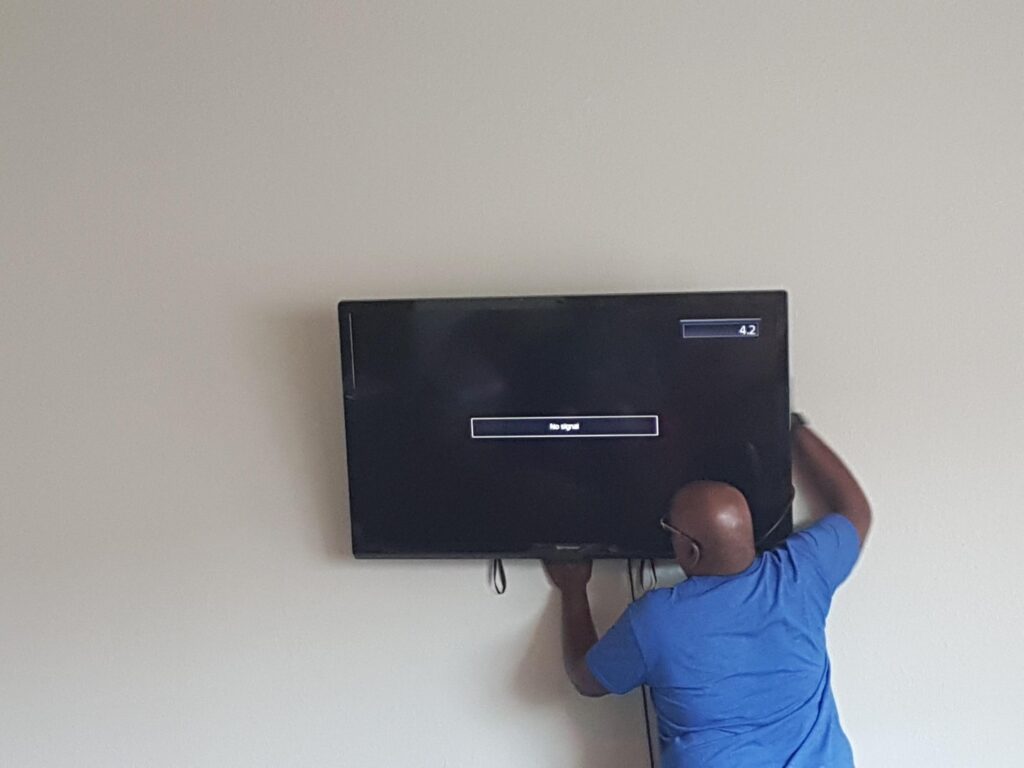 Kevin mounting the TV on the wall in our oldest daughter's loft apartment.